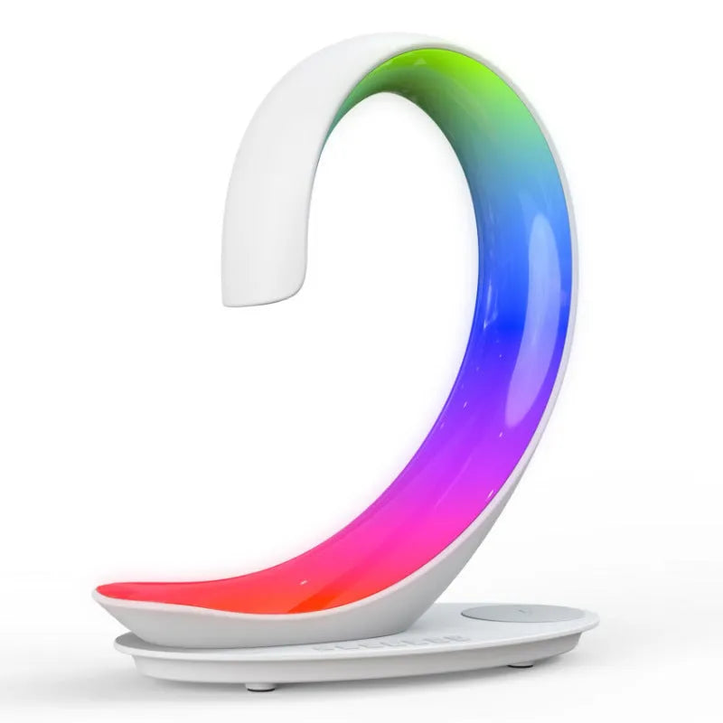 White swan-shaped desktop gadget with wireless charging pad, Bluetooth speaker, and colourful LED atmosphere light.