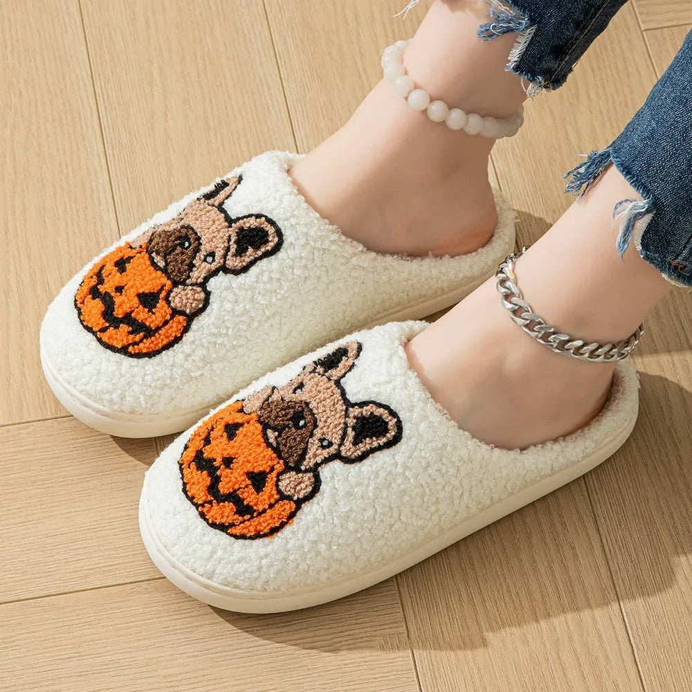 Black and white Halloween slippers with pumpkin pattern, plush upper, and textured rubber sole.