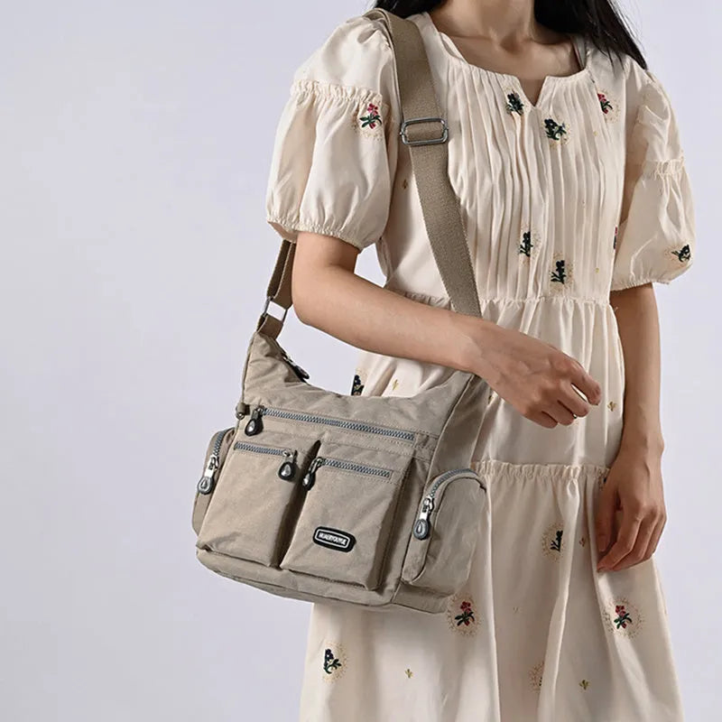 Women's waterproof nylon crossbody shoulder bag in black with multiple pockets and telescopic handle