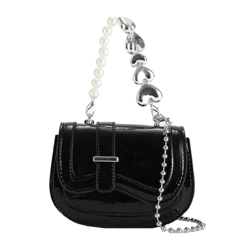 Silver women's PU leather mini tote saddle crossbody bag on a table.