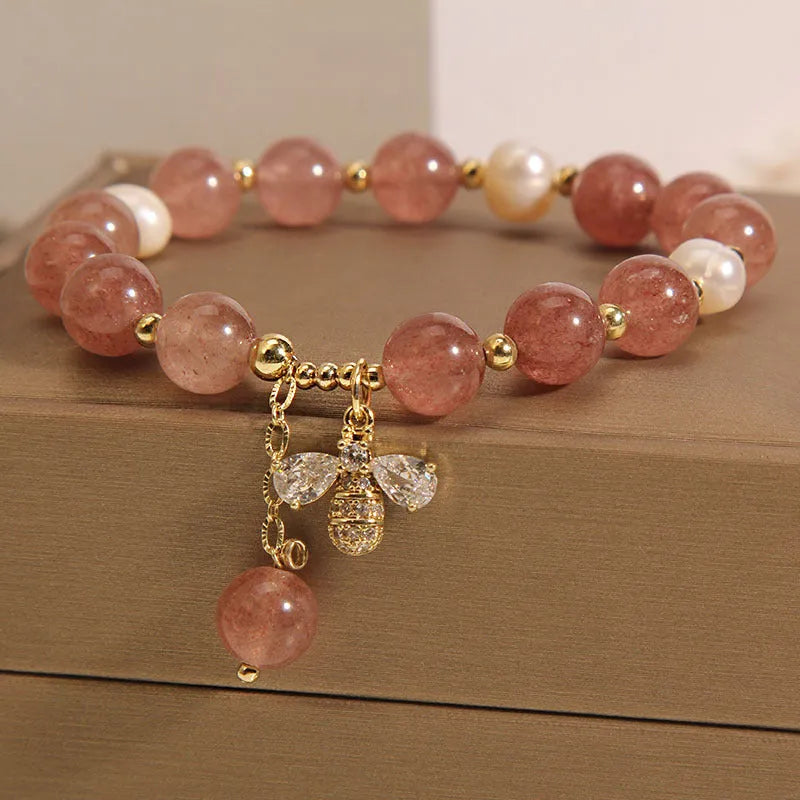 Women's bracelet with strawberry quartz beads, three freshwater pearls, and sparkling zircon details on a metal chain.