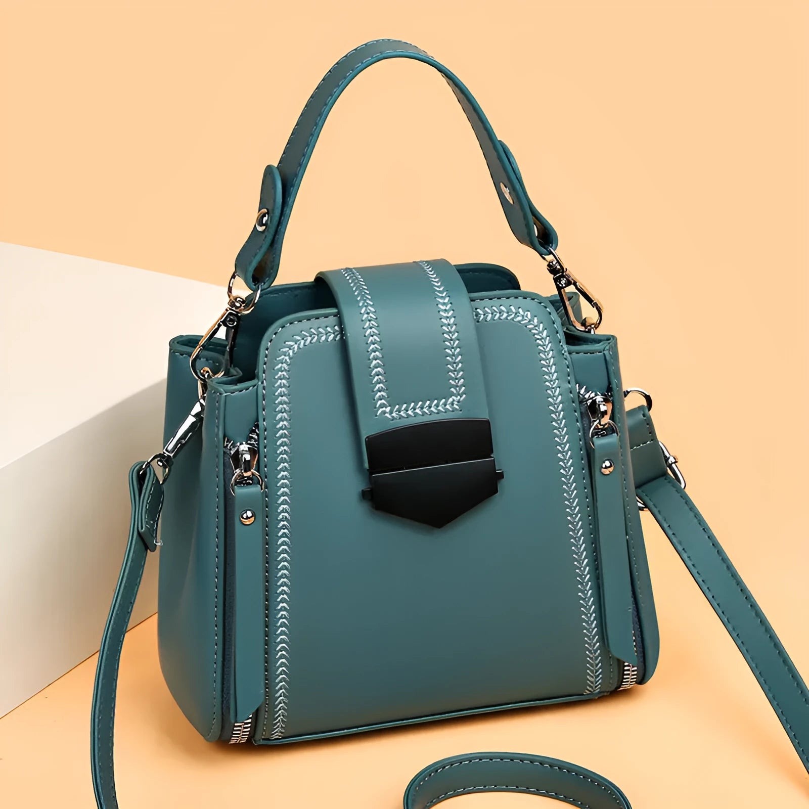 Small square vertical ladies handbag in soft textured PU leather, showing sewing thread detail.