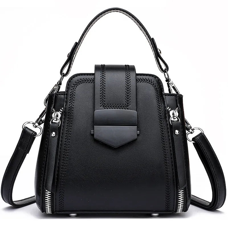 Small square vertical ladies handbag in soft textured PU leather, showing sewing thread detail.