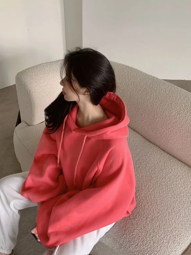 Watermelon red mulberry silk sleeveless hooded sweater for women on a hanger.