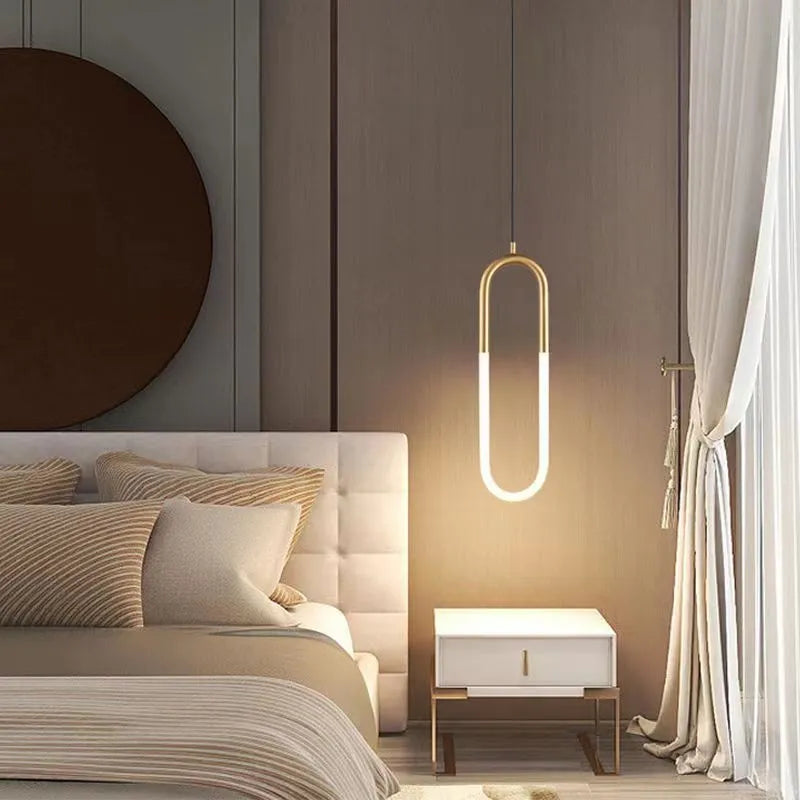 Modern Nordic style U-shaped white pendant light hanging above a wooden bedside table.