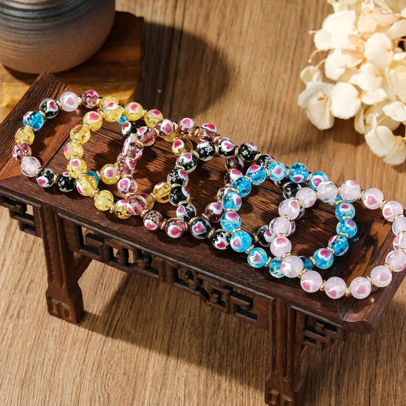 Handmade glass bracelet with swallowing gold beast charm and heart-shaped fluorescent glaze beads