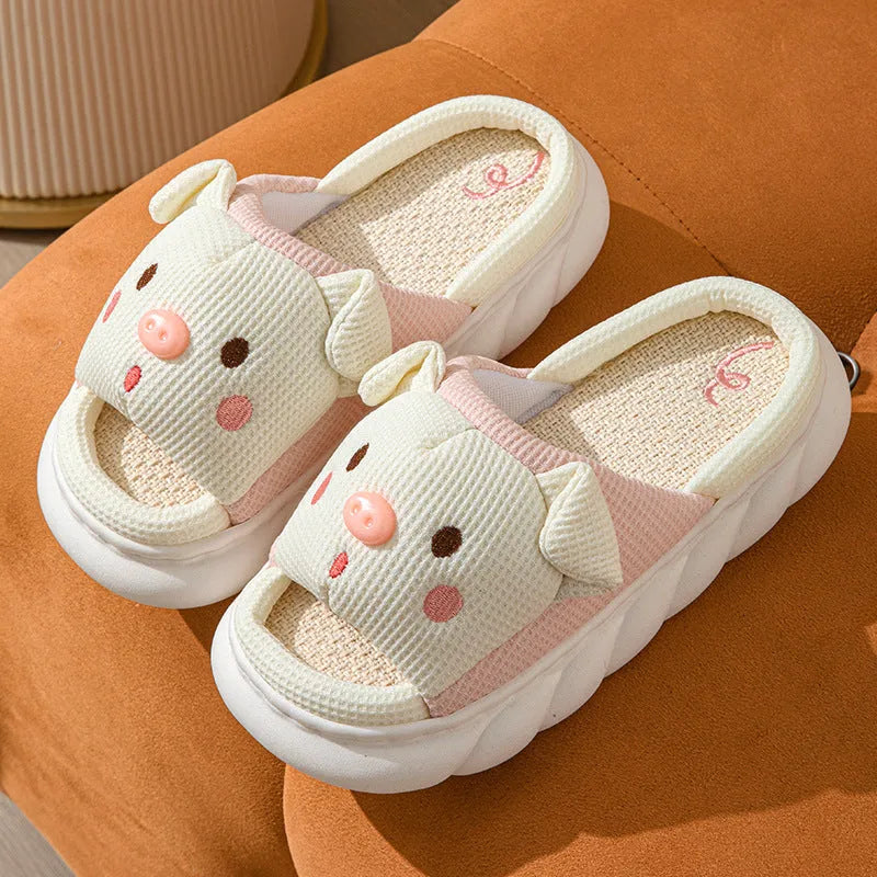 A pair of Piggy Cute linen couple slippers in open toe flip flop style on a plain background.