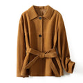 Yellow brown cashmere mid-length coat with a leather belt and a flat Peter Pan collar on a hanger.
