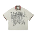 Men's loose blue short-sleeved top with a graffiti-style print on the lapel and an asymmetric hem.