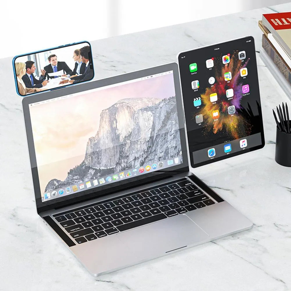 Black aluminium laptop phone holder with magnetic mount attached to side of silver laptop