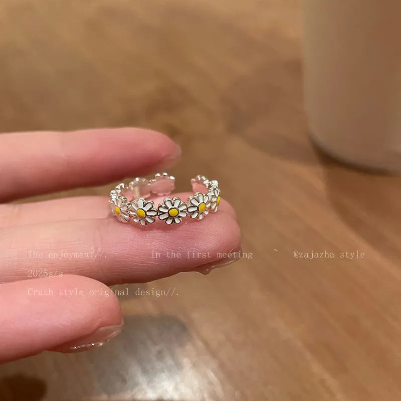 Women's adjustable copper ring with a little daisy and pearl decoration on a white background.