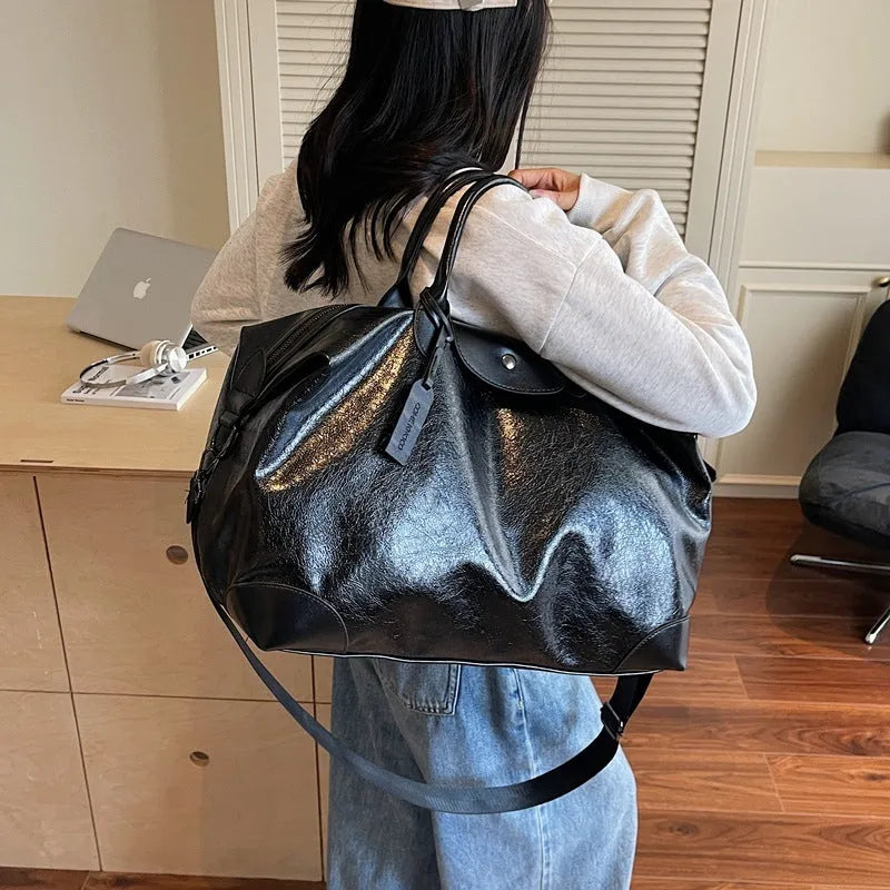 Large hand-carry travel bag for women in black colour showing storage capacity