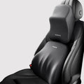Black geometric pattern memory foam car lumbar pillow and matching headrest on a car seat.