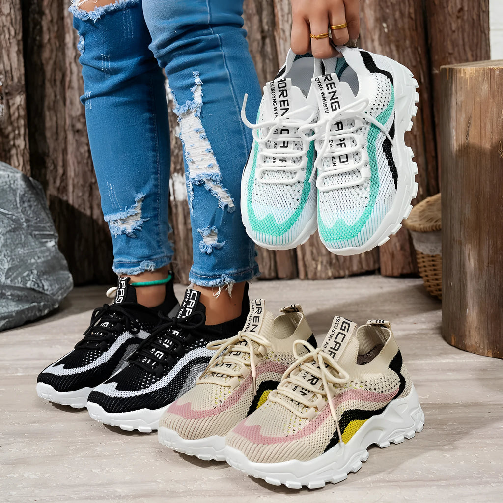 Women's casual sports shoes with mesh upper and lace-up front in black and white colour