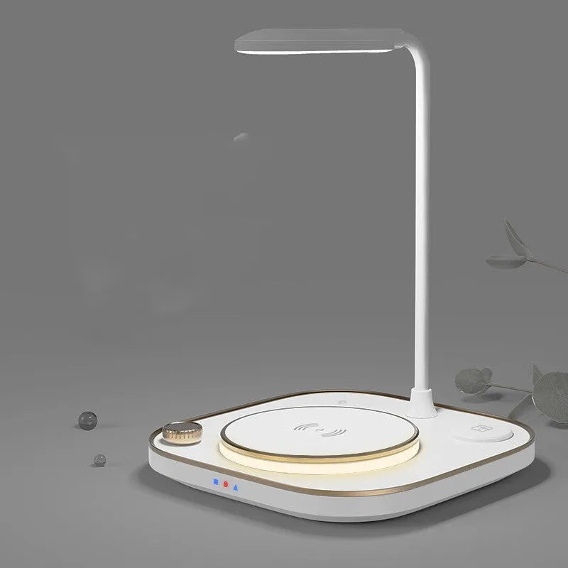 Black three-in-one wireless magnetic charging dock with desk lamp and USB port on a wooden desk.