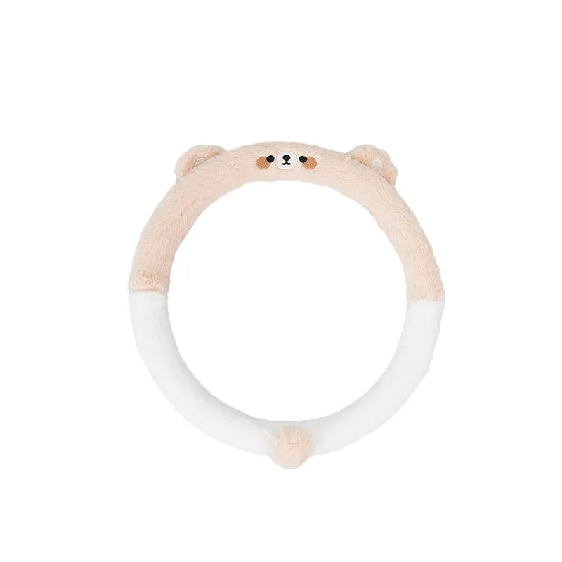 Plush winter steering wheel cover with embroidered bear design, shown on a car steering wheel.