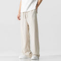 Man wearing beige bamboo fibre drawstring waist trousers with a cropped, straight leg.
