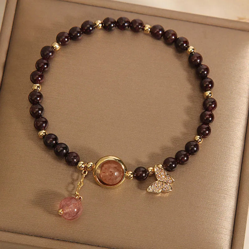 Black butterfly pendant bracelet with stone construction and red rock elements