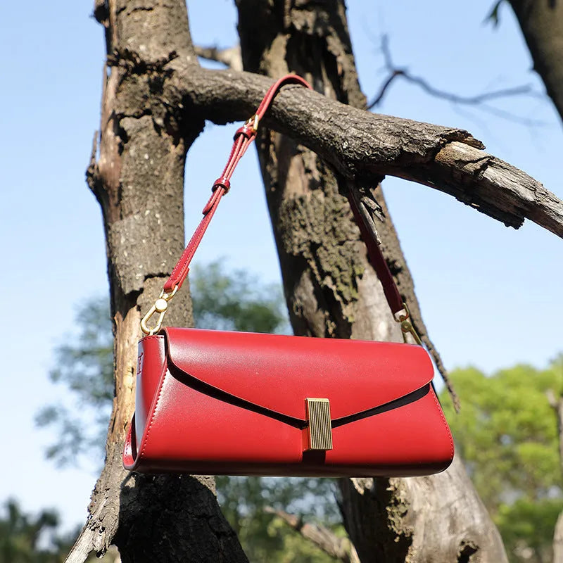 Women's leather cross-body bag with clamshell design and pillow shape in multiple colours