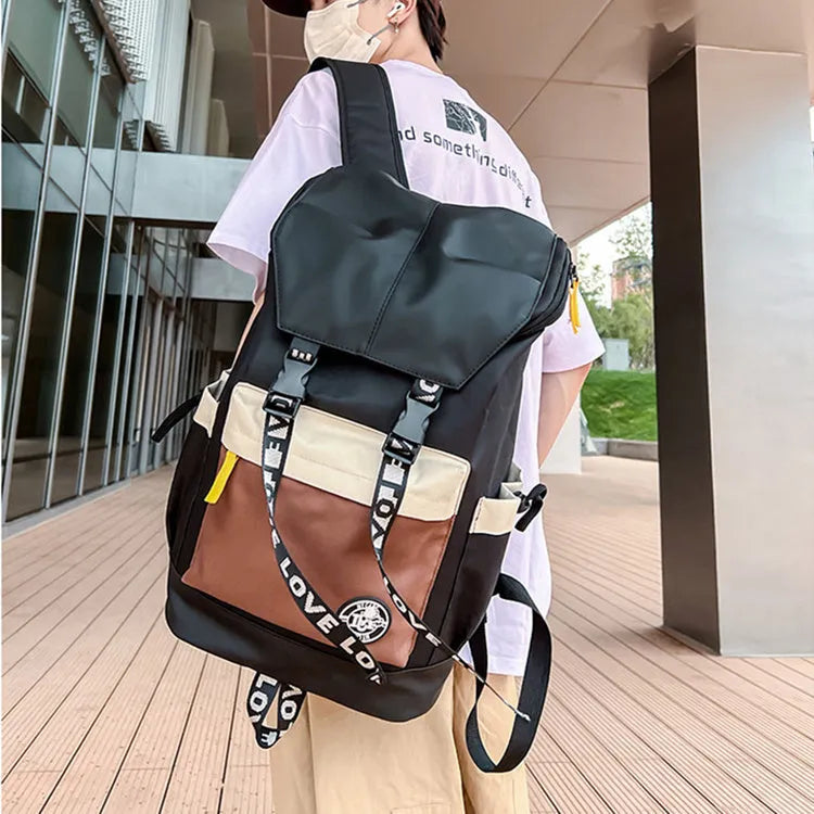 Oxford cloth backpack in black shown with handheld grip and shoulder straps.