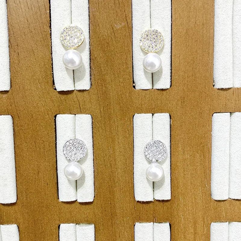 Round diamond studded pearl earrings in gold finish with post back closure