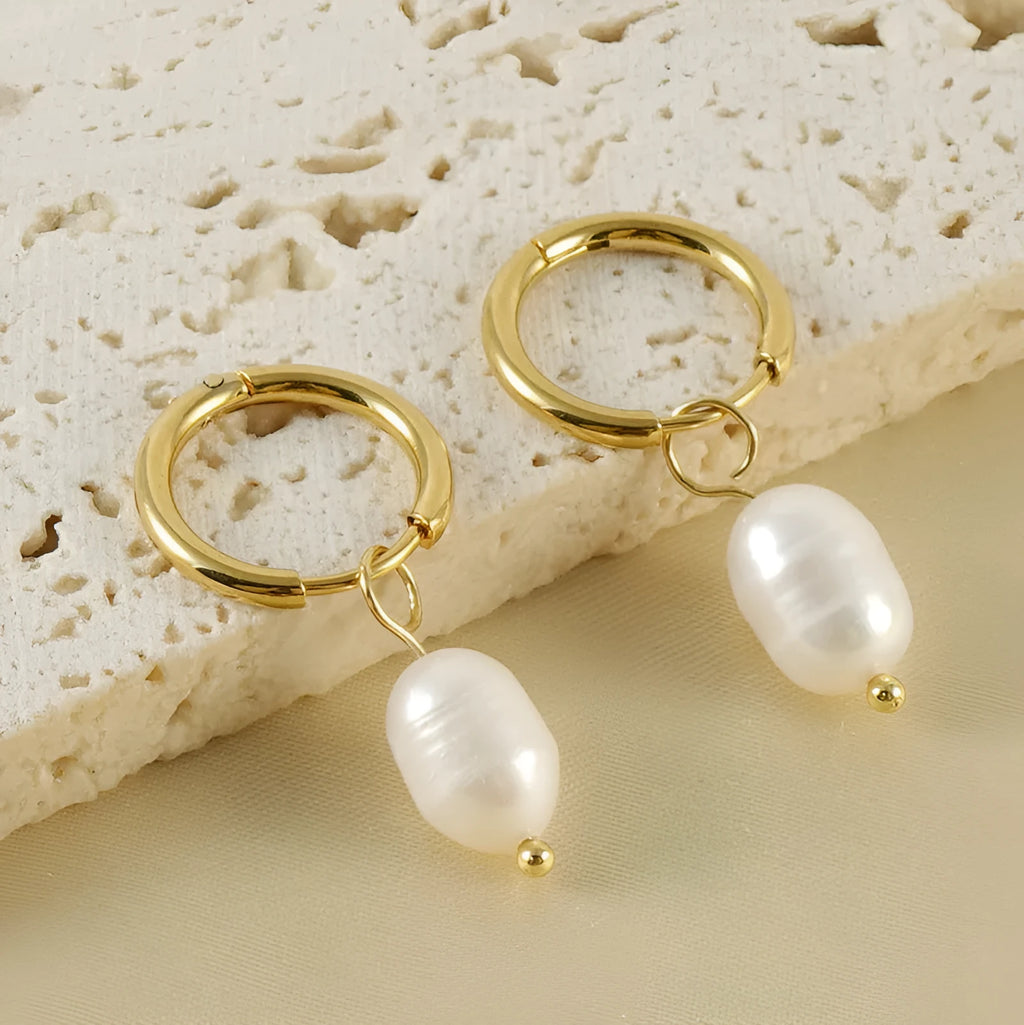 Gold geometric women's earrings with a pearl detail on a white background