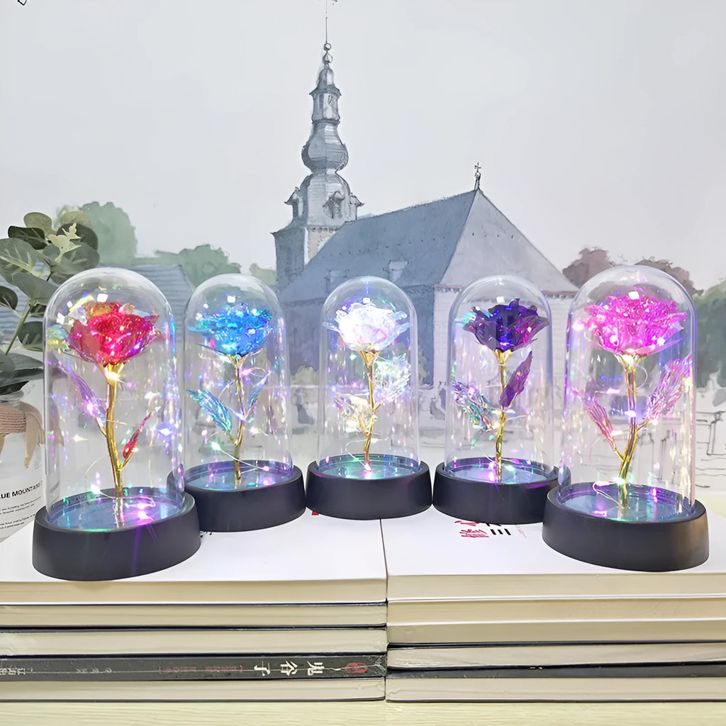Small glass cover night lamp with plastic flowers, showing coloured LED light options on a black base.