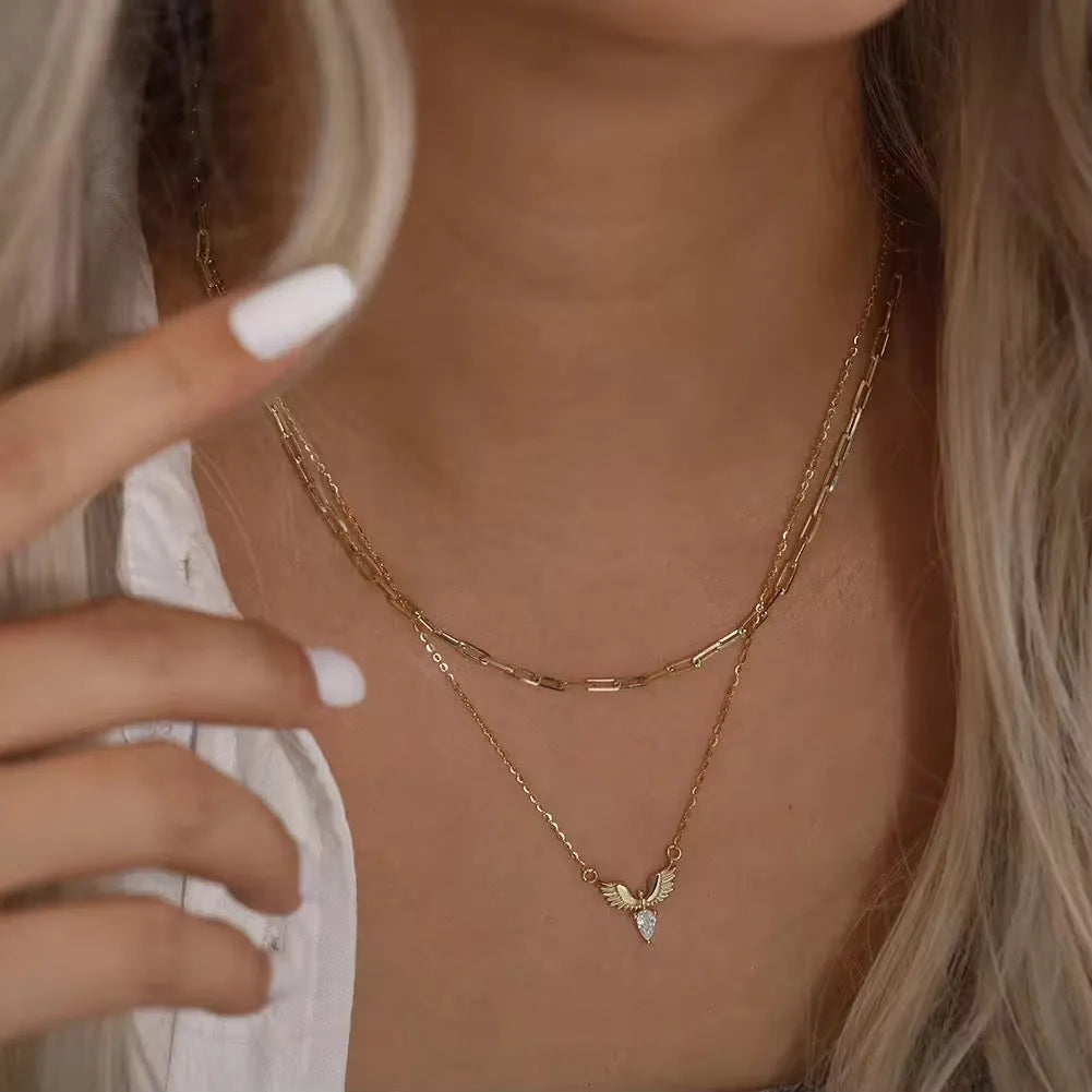 Close-up of a women's adjustable silver necklace with an eagle pendant on an O-ring chain, showing white gold and yellow gold colour options.