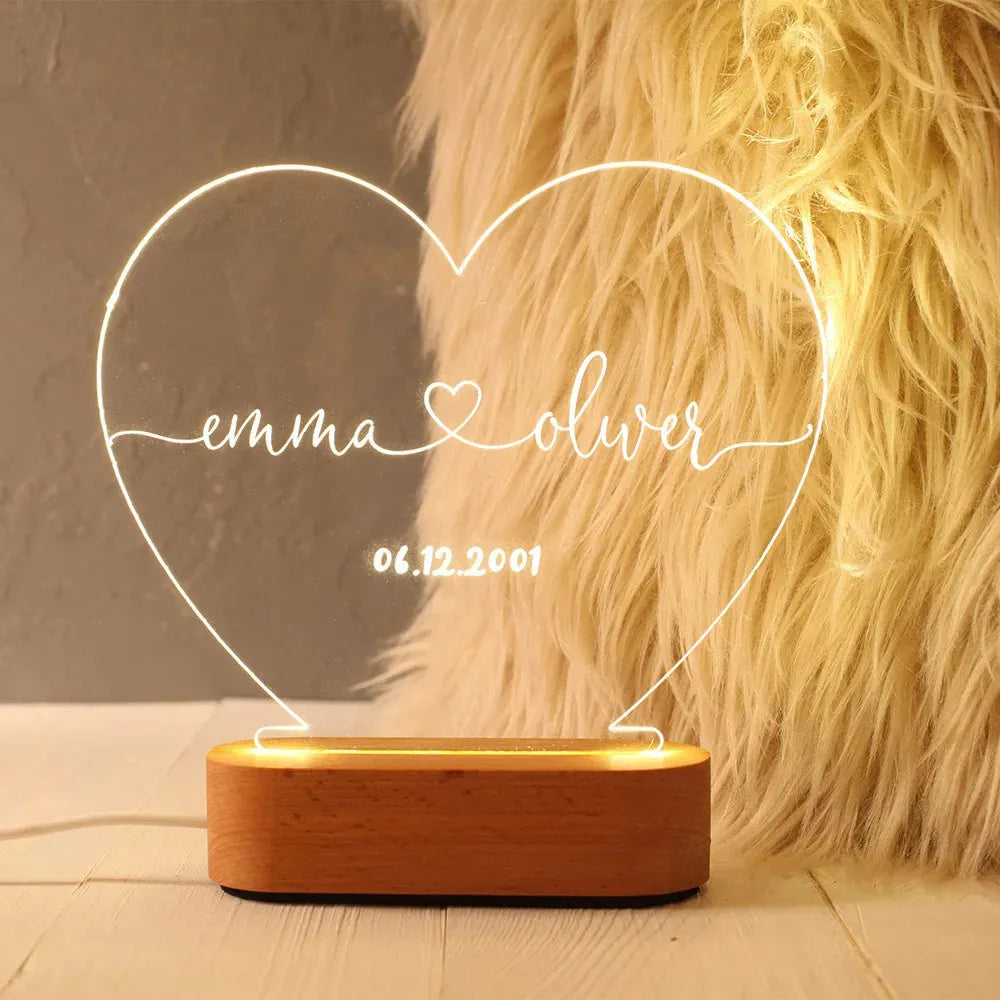 Custom engraved acrylic night light with names and date, illuminated by an LED base.