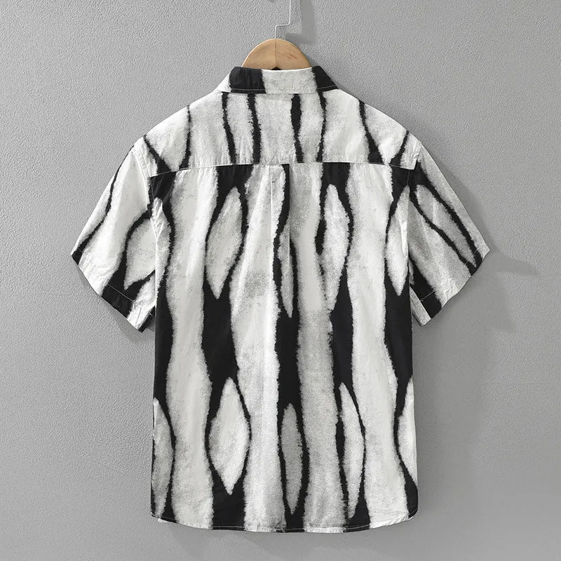 Man wearing a black and white retro striped short sleeve loose-fit cotton shirt.