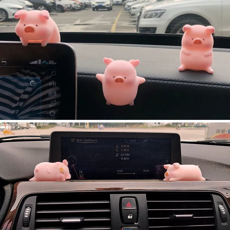 A cute cartoon pig resin figurine car decoration accessory on a dashboard.