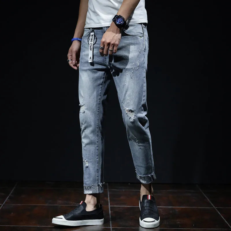 Light blue denim cropped jeans with ripped details on straight leg