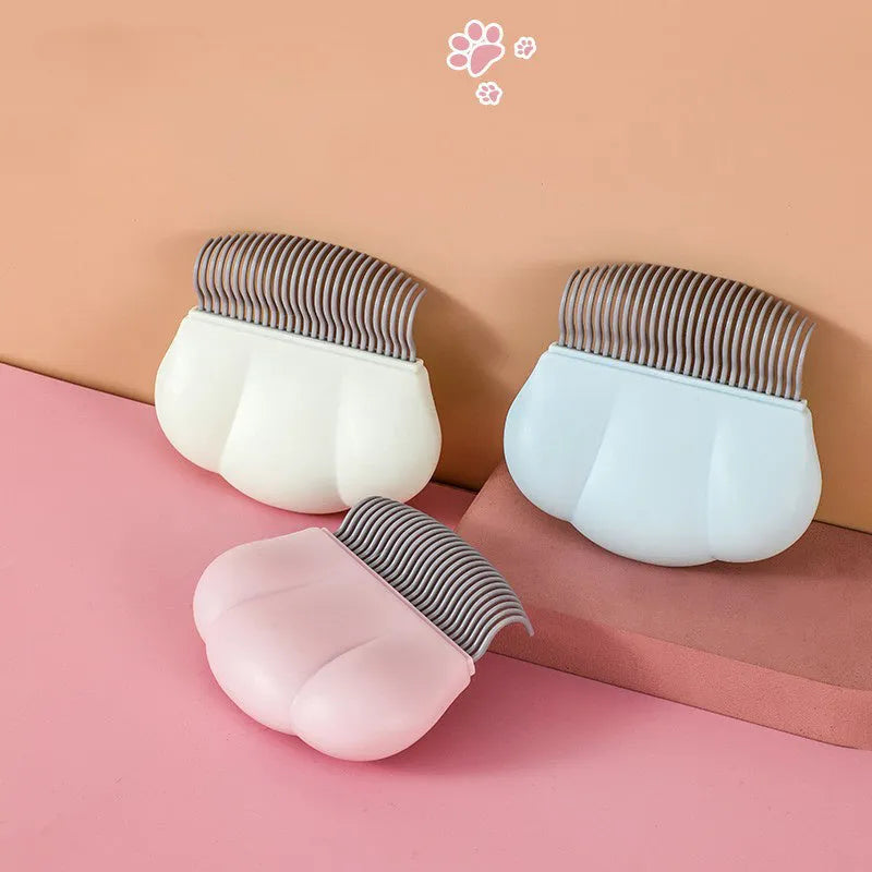 Paw Soft deshedding grooming brush for cats and dogs on a white surface.