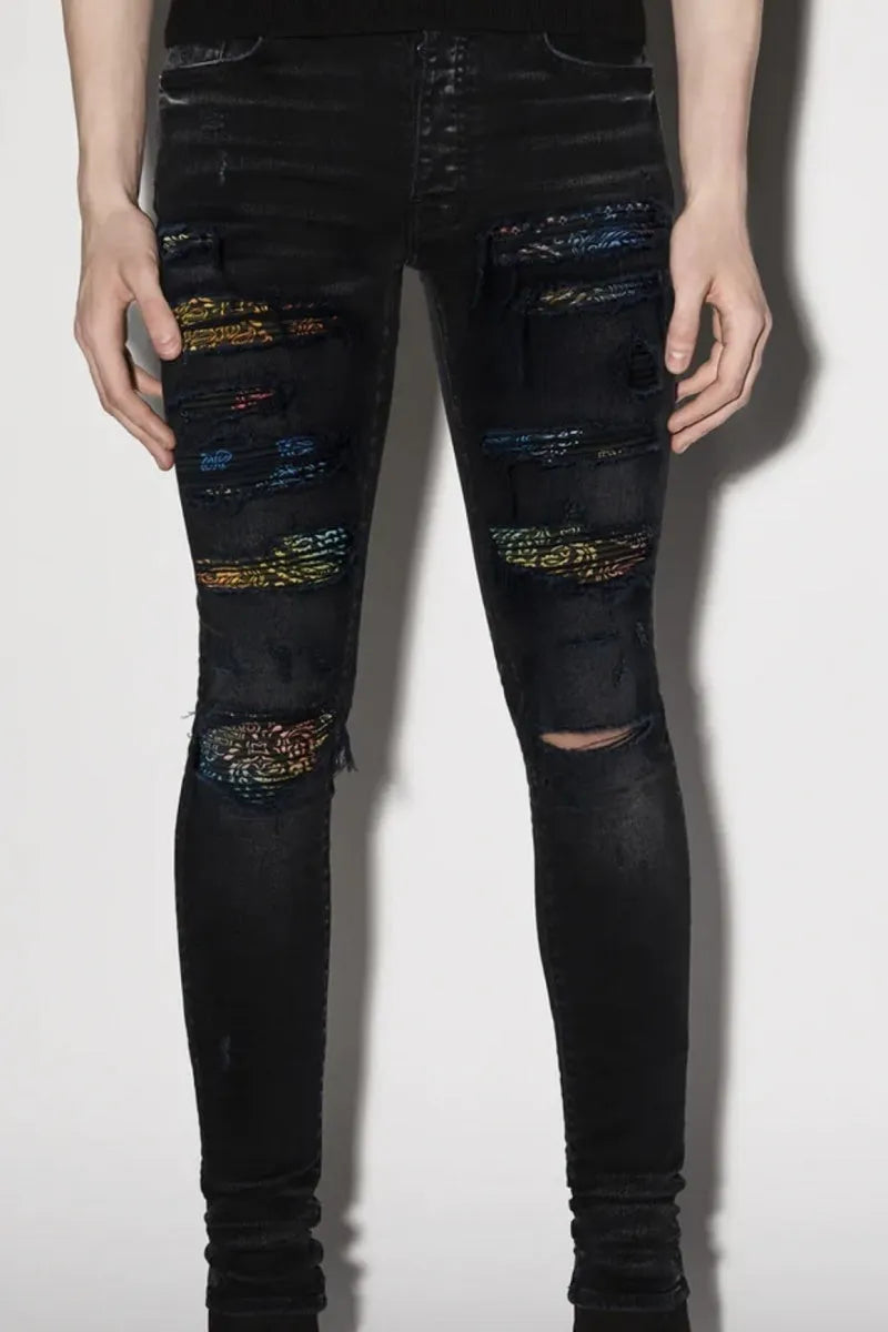 Men's black tattered stretch denim jeans with printed patch on a white background, front view