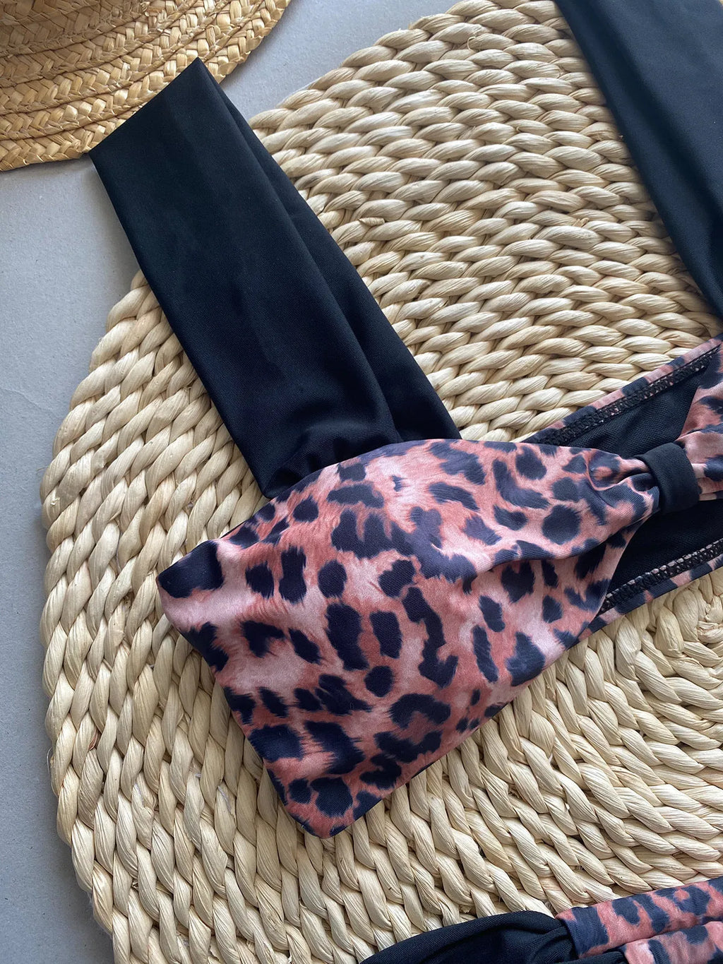 Women's black and leopard print tube top bikini set laid flat, showing the sleeveless top and briefs.