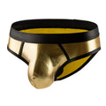 Man wearing low-waist gold bikini swim briefs on beach