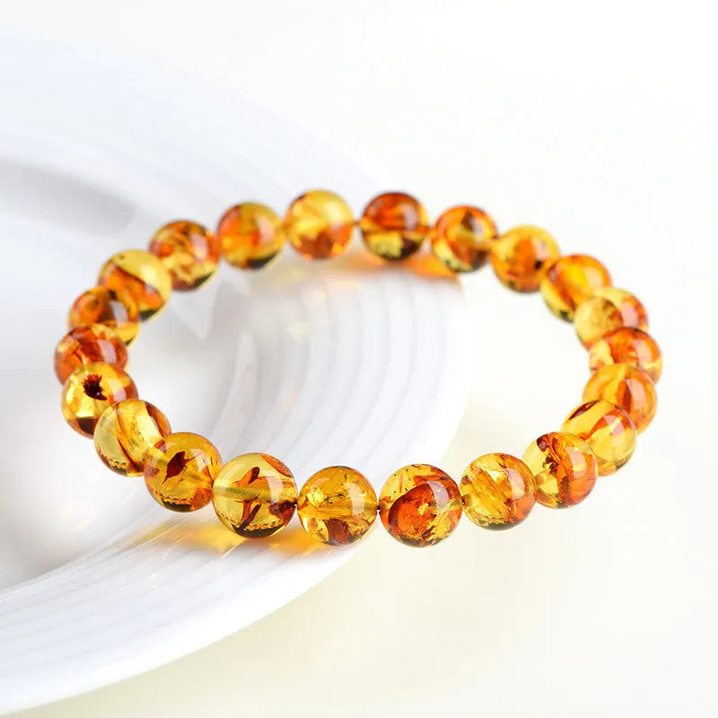 Natural yellow piebald amber bracelet with geometric design on a wrist.