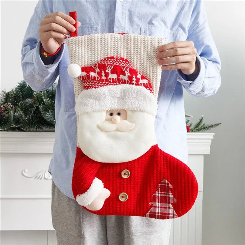 Large red and white knitted Christmas stocking with Santa Claus or Snowman design on a fireplace mantel