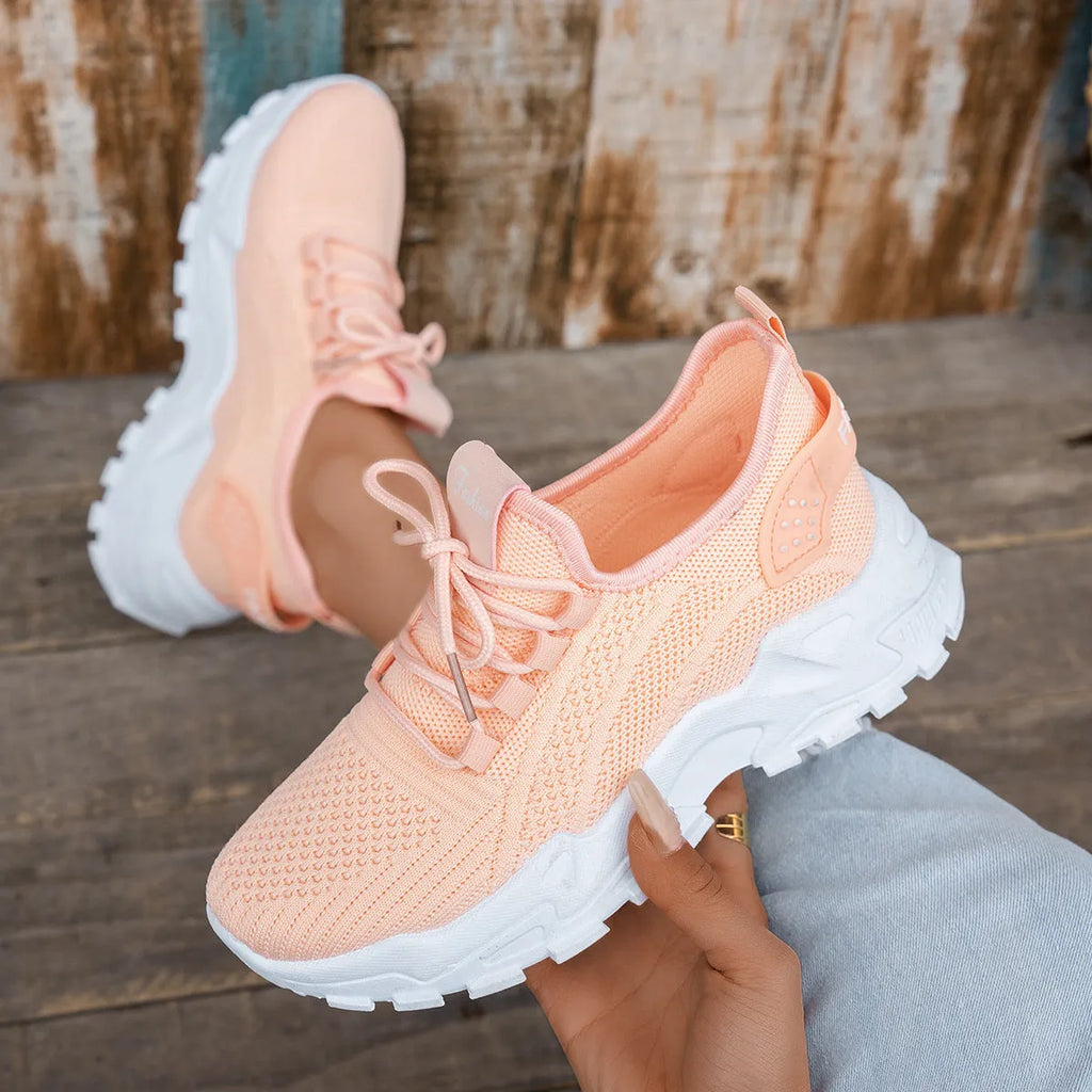 Women's white Flyknit mesh casual sports shoes with flat heel and lace-up front on a plain background.