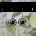 Handmade geometric silver earrings with turquoise flower disk and ethnic patterns in red, blue, or black.