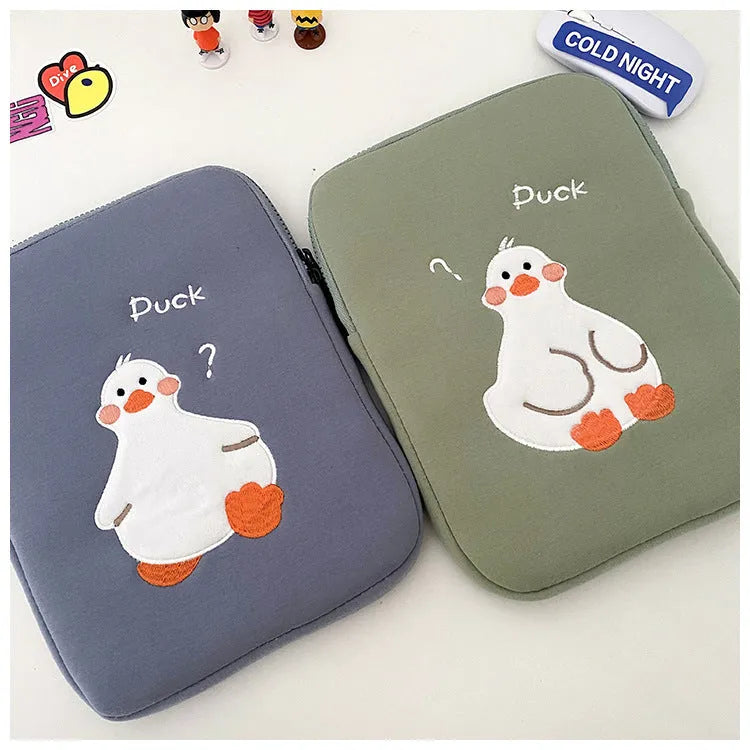 Blue cotton tablet case with embroidered cartoon duck design, showing zipper closure and protective frame.