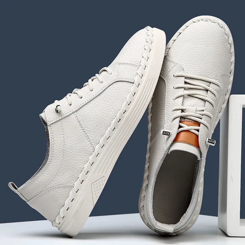 Men's beige and black cowhide leather sneakers with round toe and visible stitching on a white background.