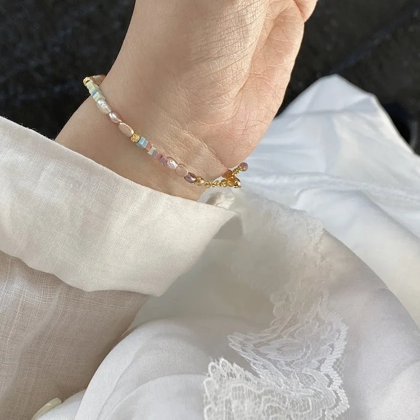 Women's natural pearl bracelet and necklace set with a purple and gold-plated clasp on a silver chain.