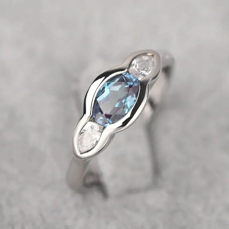 Geometric ellipse copper ring with inlaid zircon stone in a white gold tone colour.