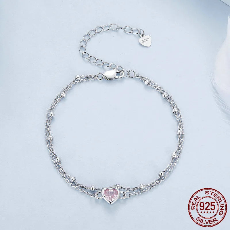Silver heart-shaped charm bracelet for women on an adjustable chain.