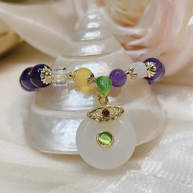 Purple amethyst crystal bracelet with money bag pendant and geometric peace buckle on wrist