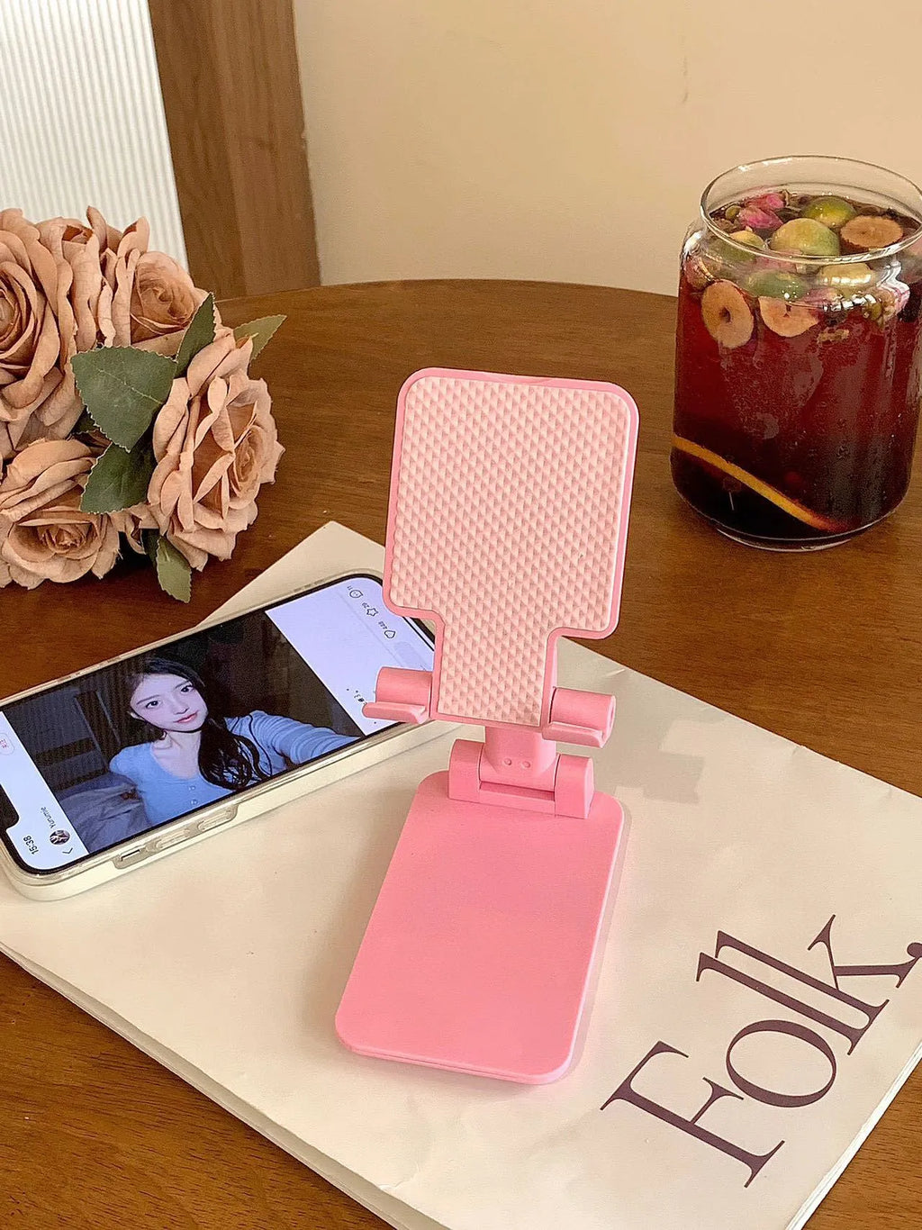 Folding plastic mobile phone stand in white, showing universal groove for hands-free viewing