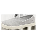 Men's beige linen cloth slip-on shoes with a round toe and shallow mouth on a grey background.