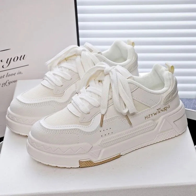 Beige children's lace-up board shoes with cross shoulder straps and a thick rubber sole, shown on a white background.