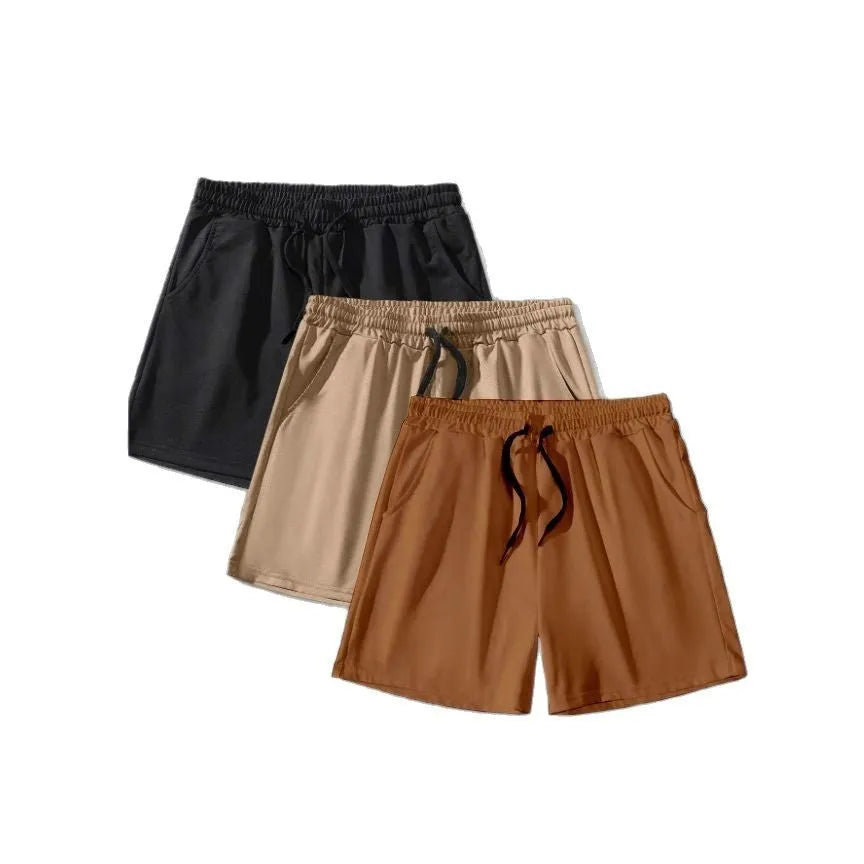 Pack of three men's solid colour drawstring shorts in black, khaki, and light brown on a hanger.